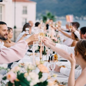 Guests clink glasses while sitting at the festive table. High quality photo